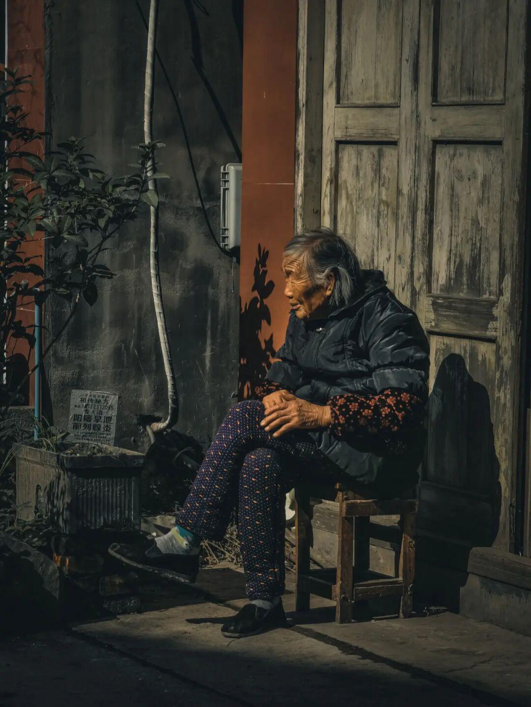 盖石老街坐着休息的老人